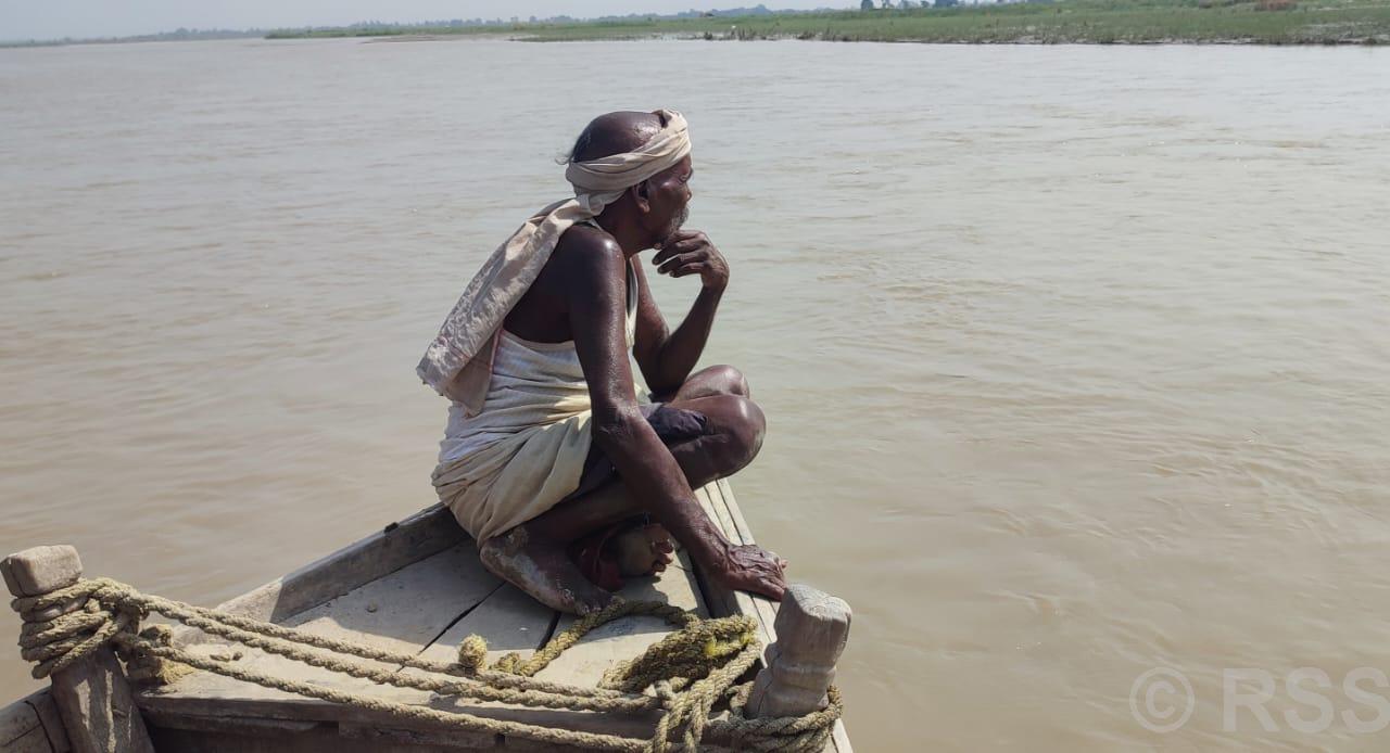 नदी किनारमा बाढी पर्खिरहेका माझी