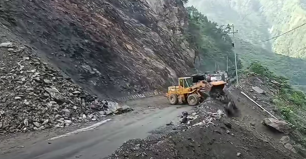 तुईनखोला नजिक खसेको पहिरो हटाइदै
